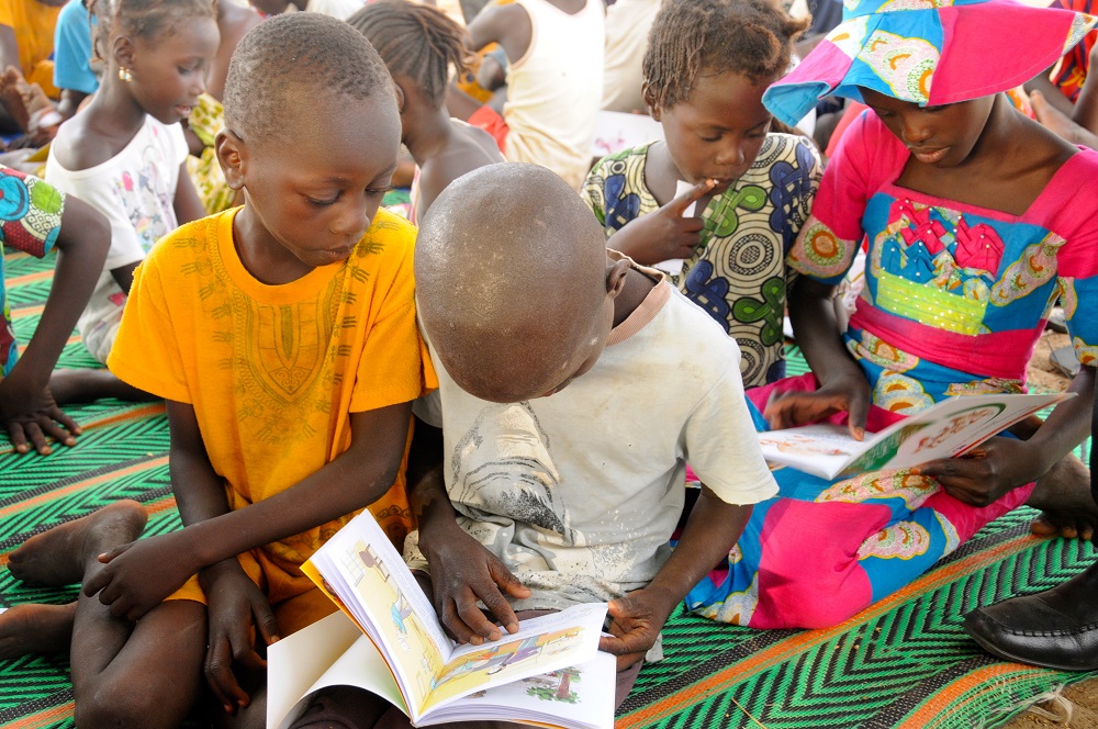 Children read together at a Literacy Boost reading club in Senegal.