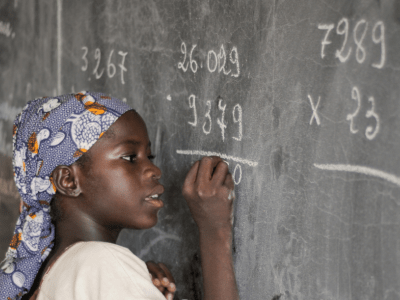 a child writing on a chalkboard