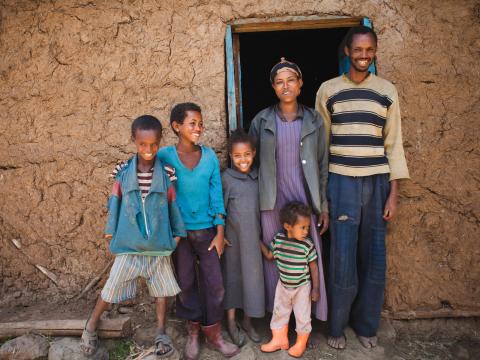 A family in Ethiopia stand outside their home