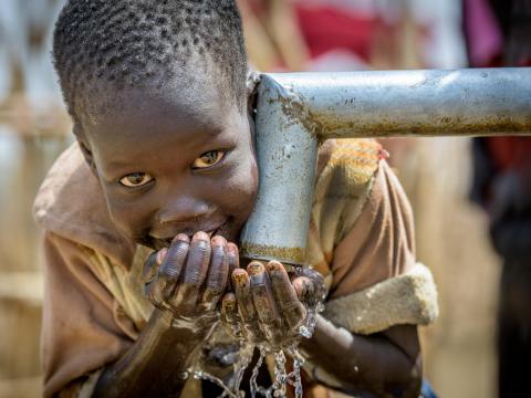 A boy in South Sudan drinks clean water