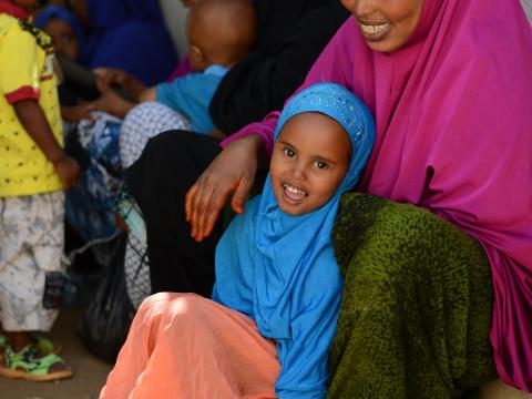 A Somali girl sits with her month