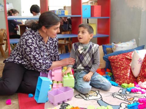 World vision staff member works with child with disability