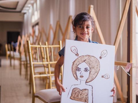 Girl proudly shows off her artwork at the workshop.