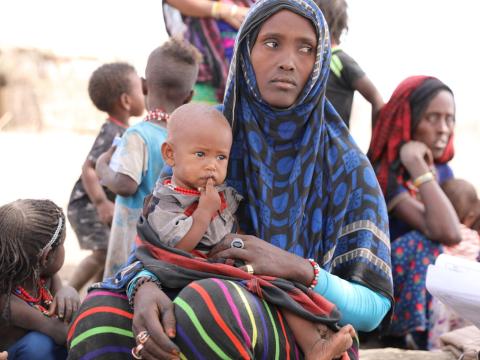 Mother displaced by violence, sits with child in Tigray Ethiopia