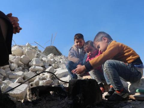 Eastern european children gathered on a pile of rubble.