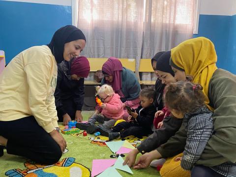 Group of Mothers supported by a volunteer on early childhood development
