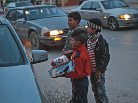 Children standing in the street, selling items