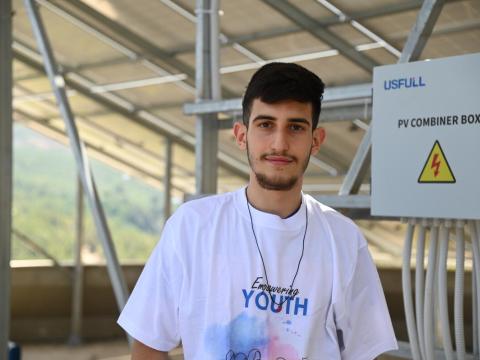 Louay, standing in front of the solar panels