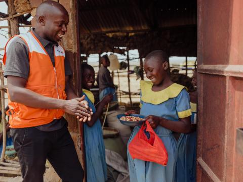 A girl receives a school meal from a WV staff member as part of the Bamba Area Programme effort in Kenya