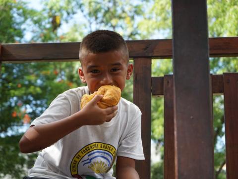 A boy enjoys a bite to eat at a World Vision-supported peace club gathering in Honduras’ San Pedro Sula area where boys and girls work within their communities to establish a culture of peace. / © World Vision
