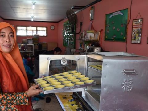 Mrs. Alfu Laila is showing the baked cookies of KSM Nusa Indah.