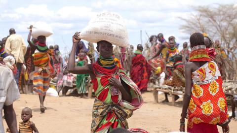 Women walk with sacks of food on their heads