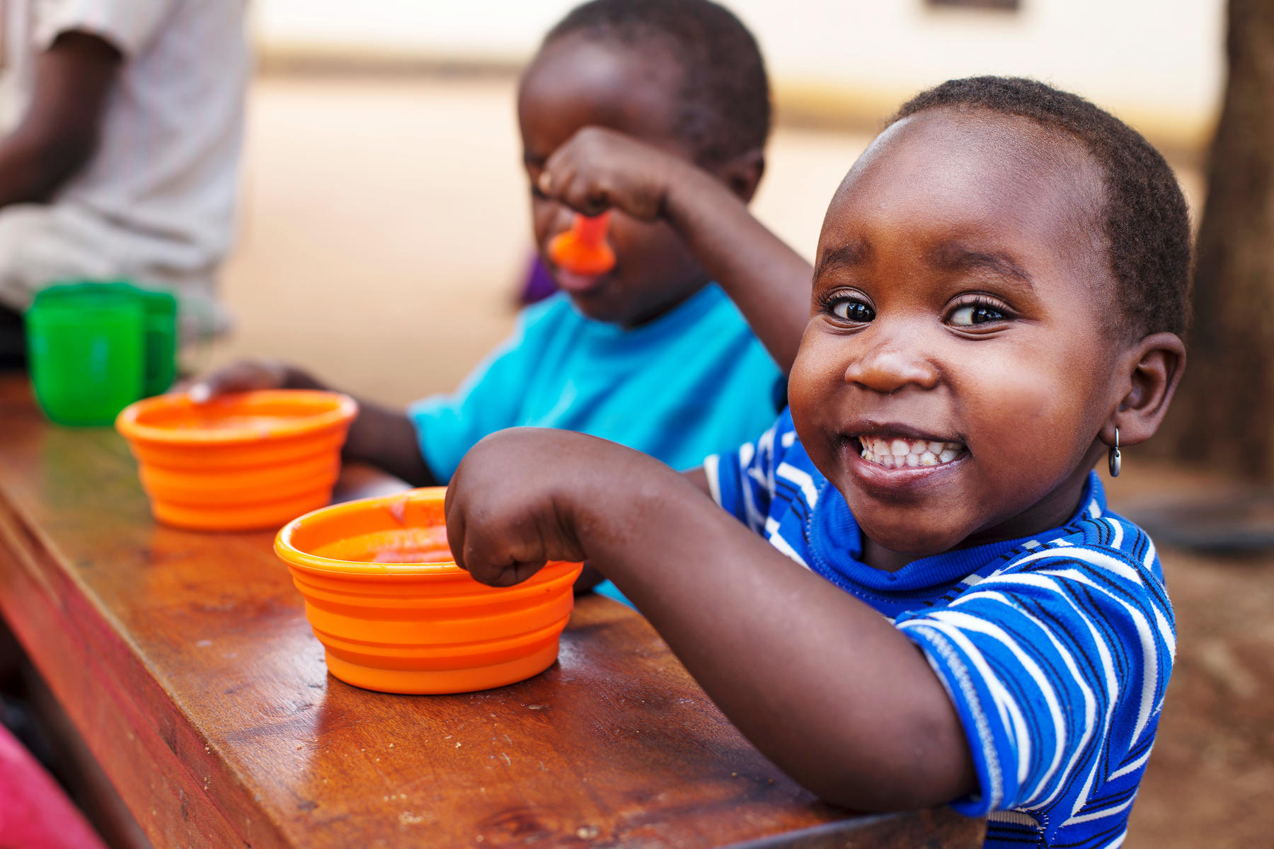 A child eats food from a bowl during lunch