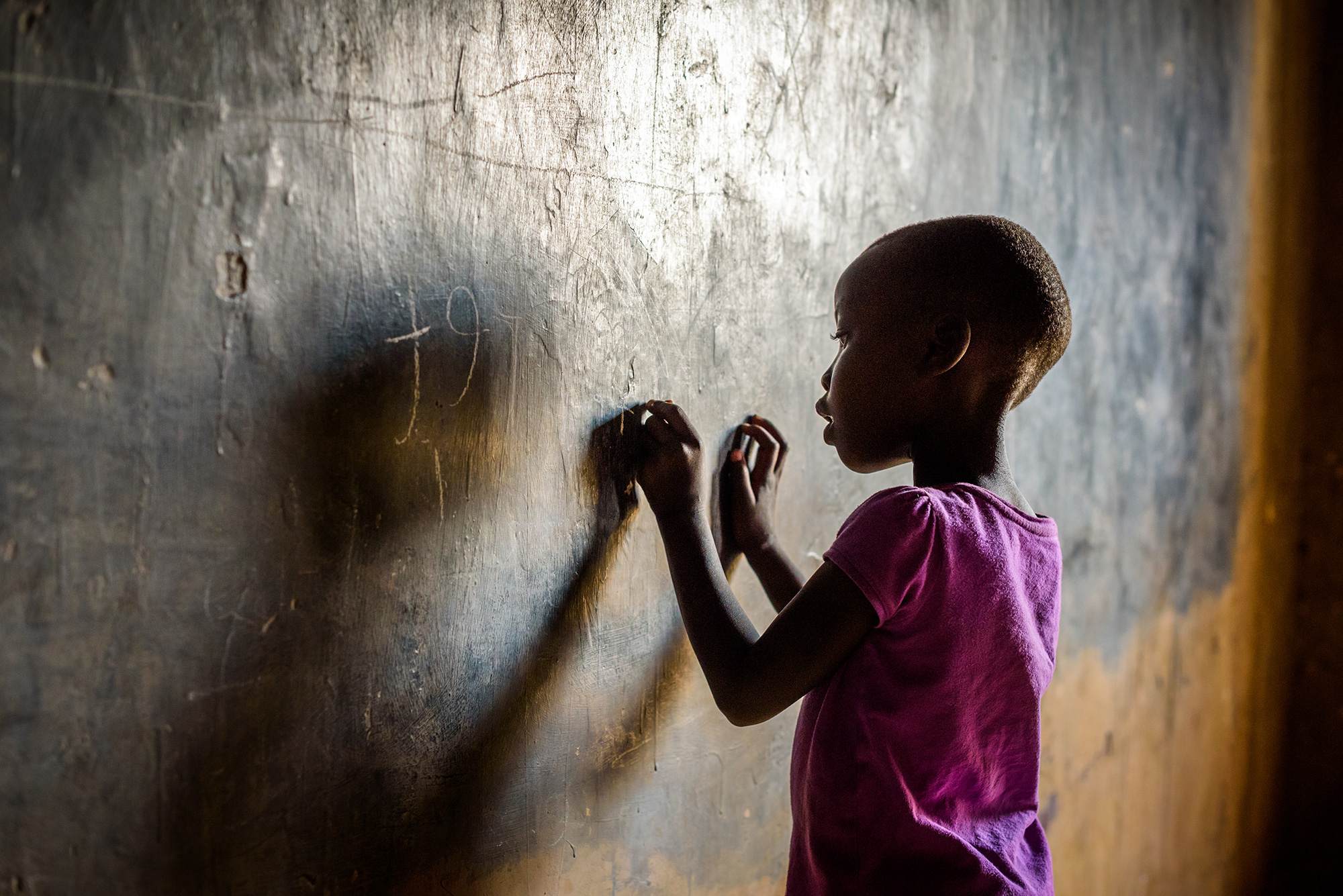 An African girl writes on a Chalkboard