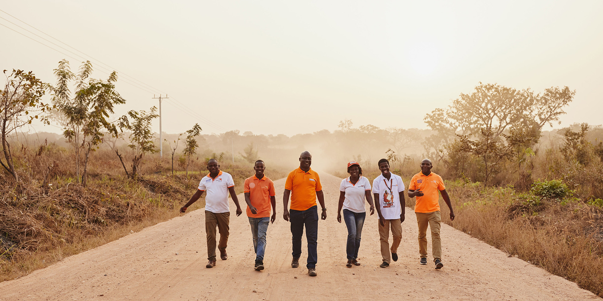 World Vision employees walk down a road in Ghana