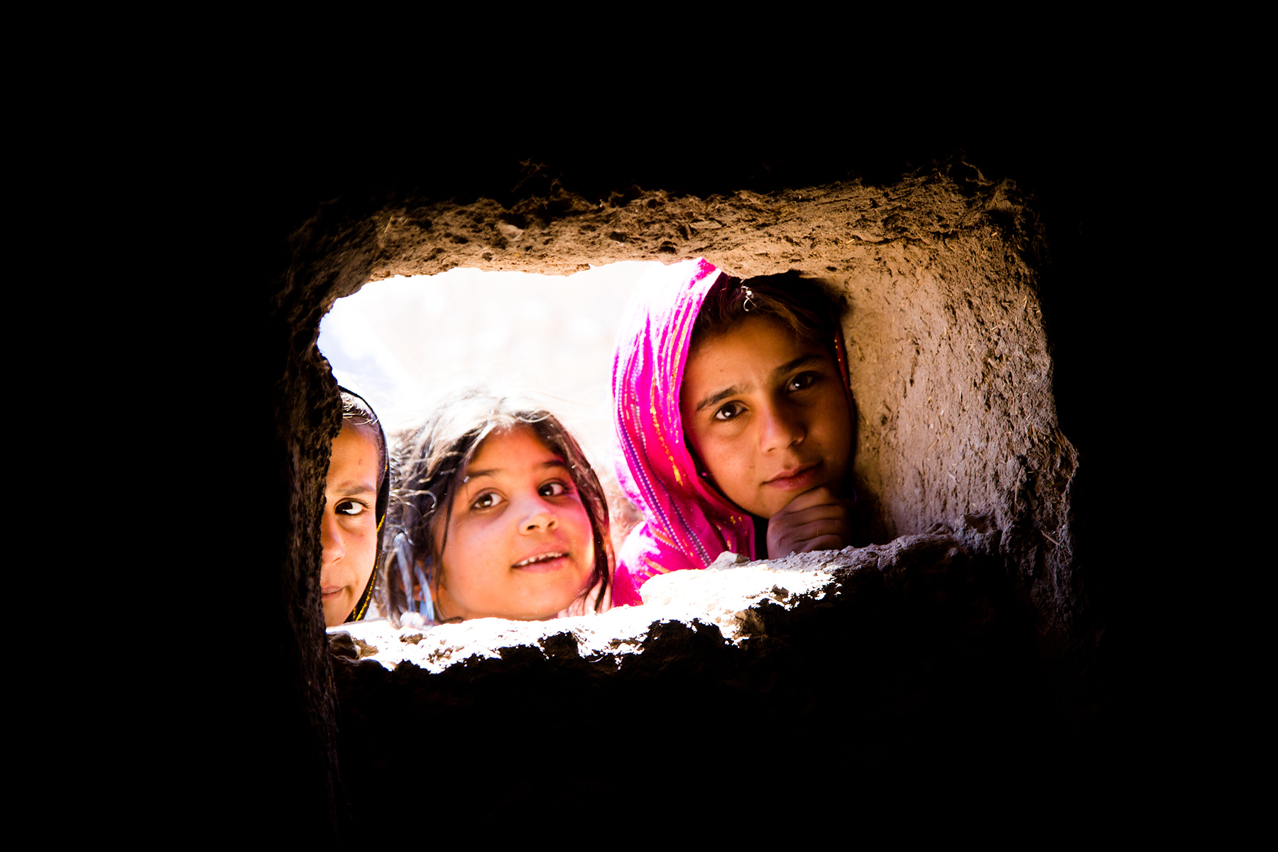 Children in Afghanistan look in a well