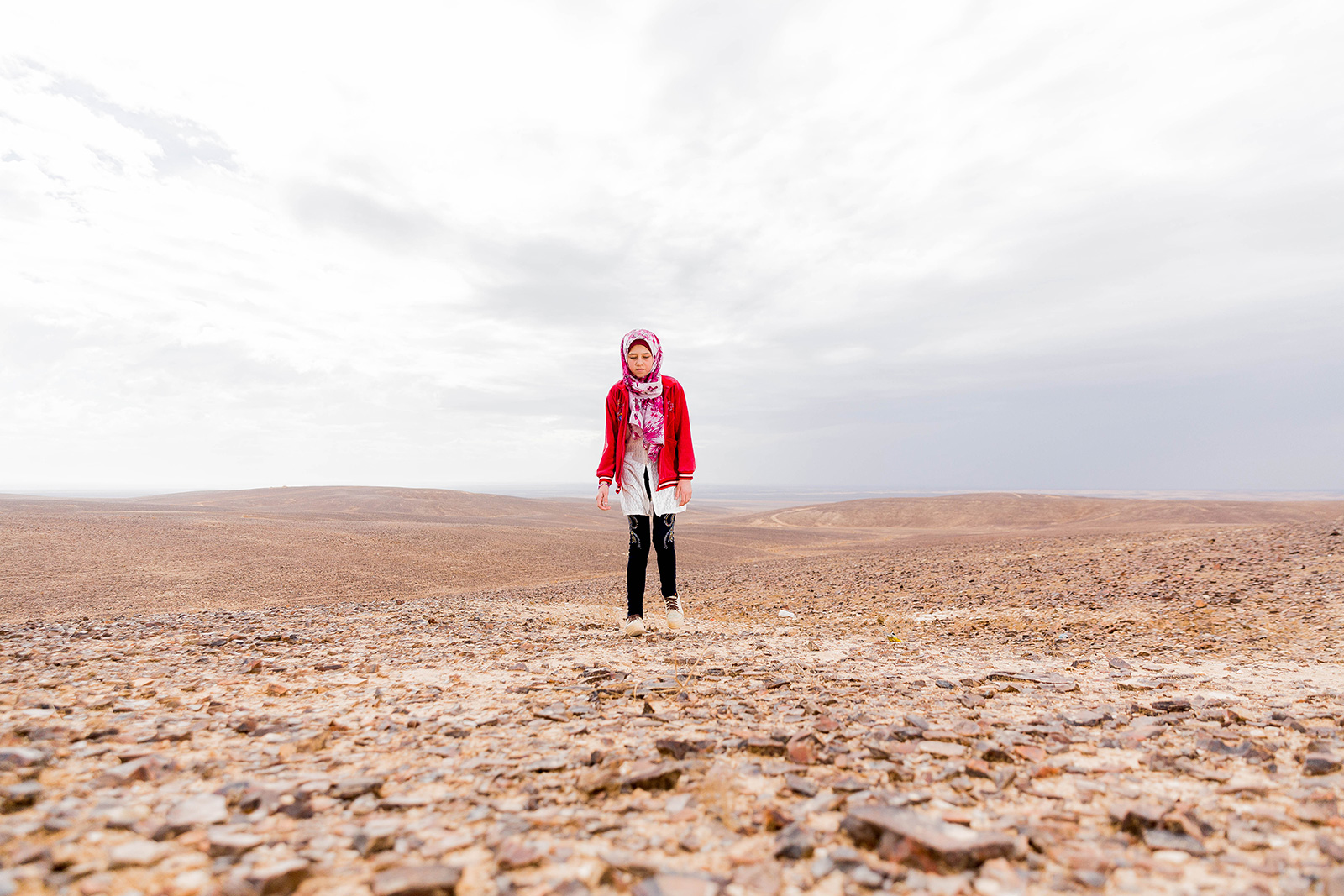 Shaima walks outside the refugee camp in syria