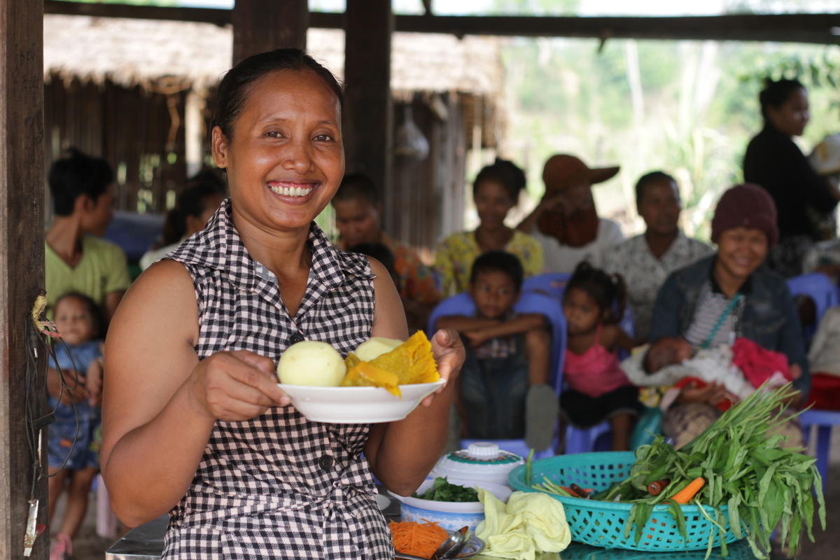 Khmer woman hold bowl of cut vegetables ready to do nutritious food cooking demonstration, Cambodia