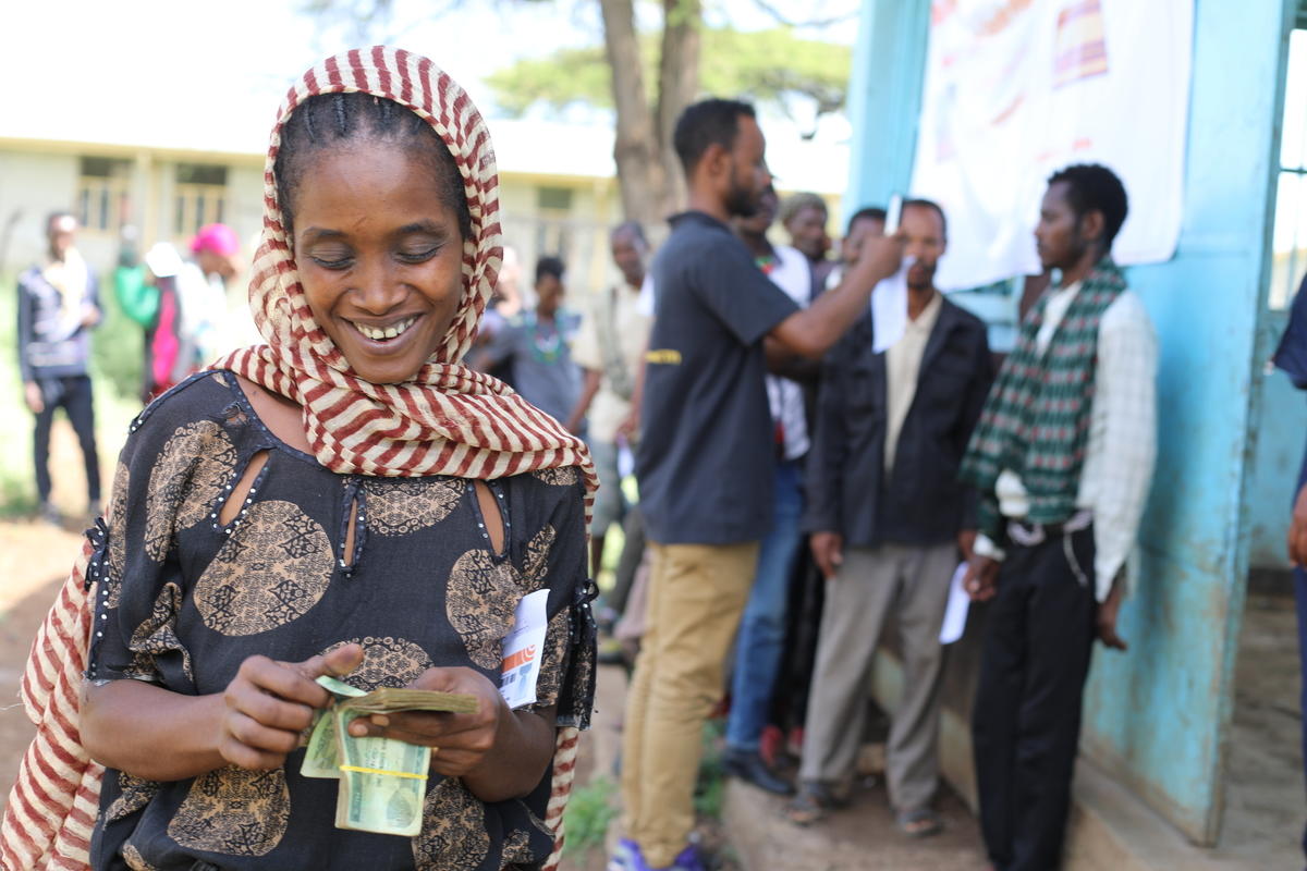 Woman counting cash in Gelana woreda, W. Guji zone, Oromia region