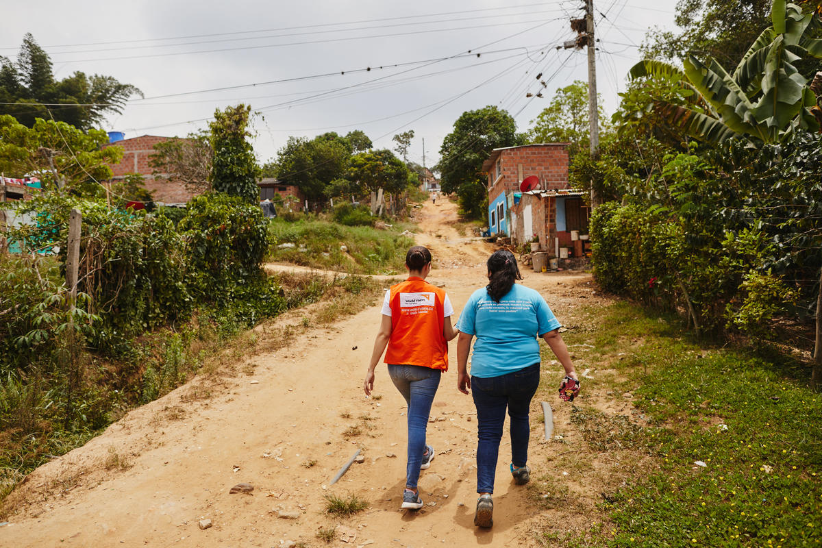 World Vision staff member walks on a dusty road in Colombia