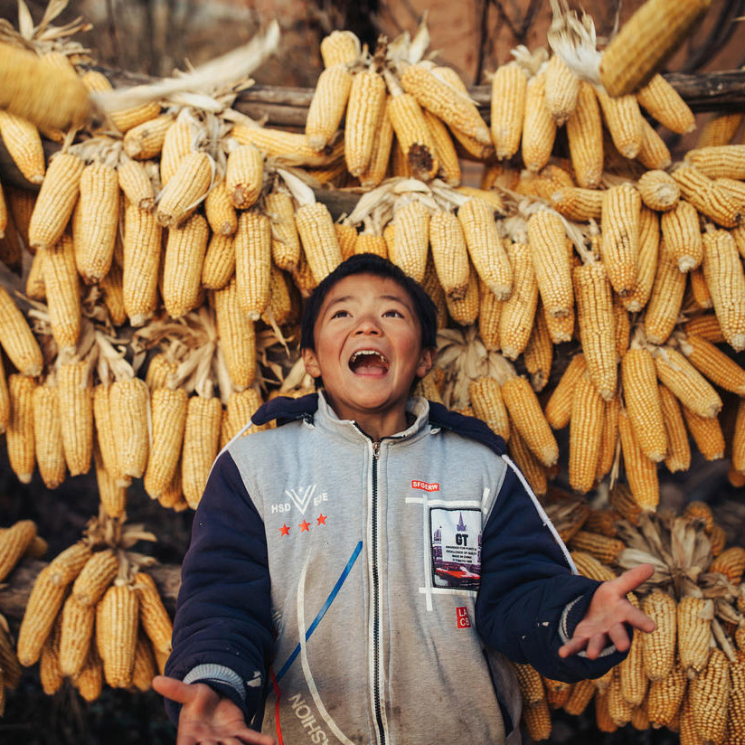 Hpppy boy in front of corn