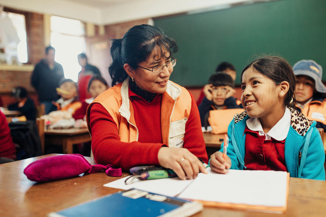 World vision staff sit with sponsored child