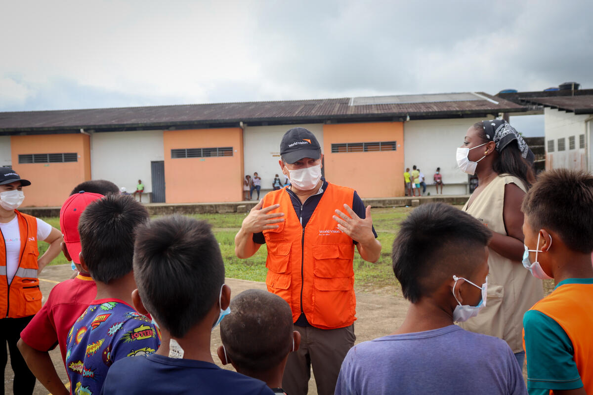 World Vision staff speaks to children