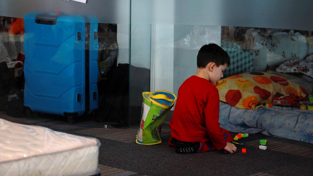 child plays with toys on the floor of a refugee center