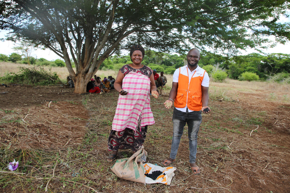 WVI staff and villager hold plants