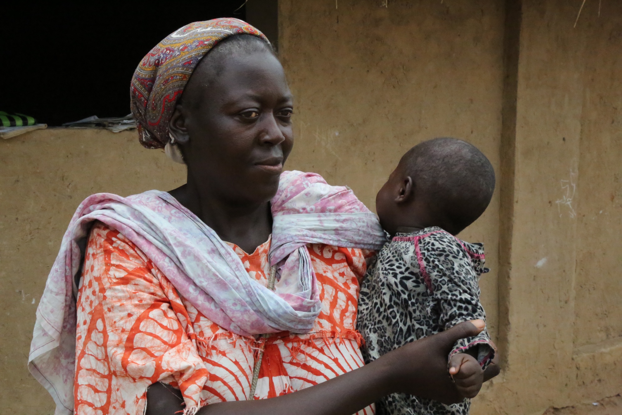 Bridget Ntumba, a mother in her 50s, poses with one of the young children at a Child Friendly Space in Kasai.