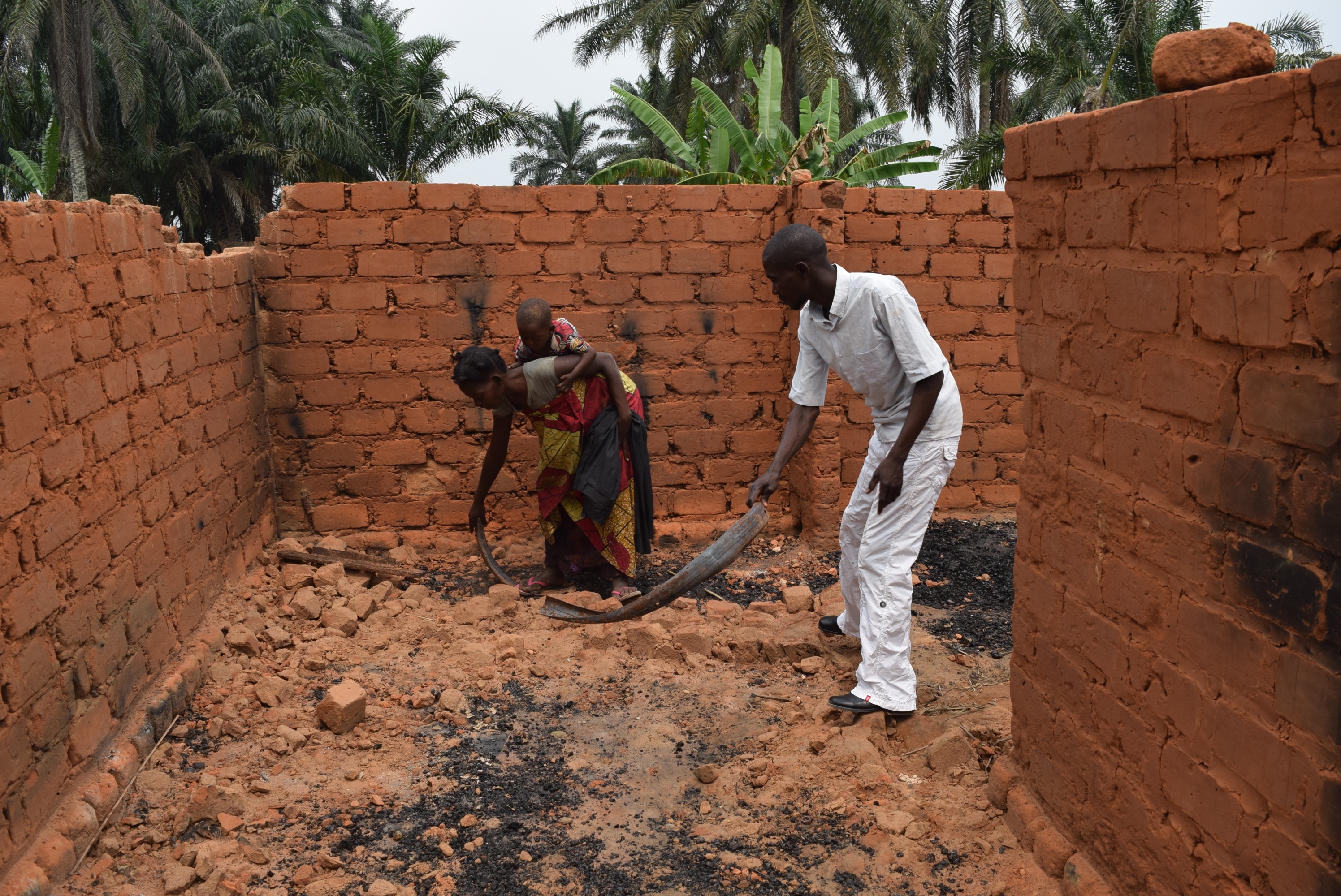 Mado and her family show the damage to their house when their village was attacked