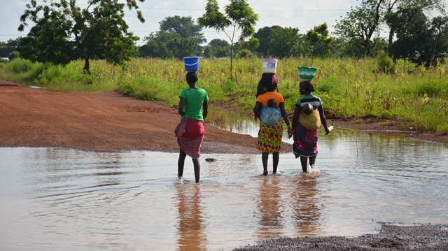 Women crossing flood waters with their babies as water is yet to recede completely 