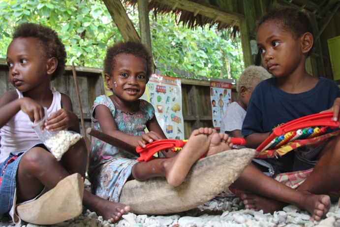 Kindy class use wooden-carved learning materials like boats, paddles and trucks.