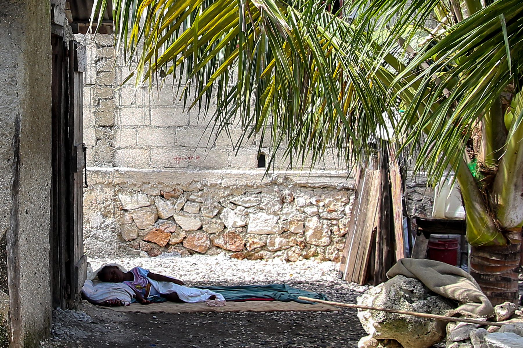 Stephanie resting outside under the shade of the palm trees