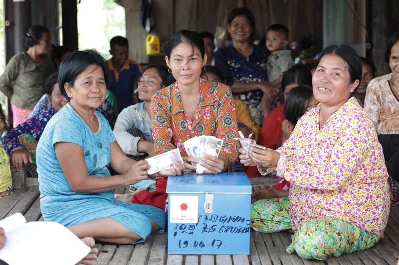 Photo of community putting their contribution into the saving box 