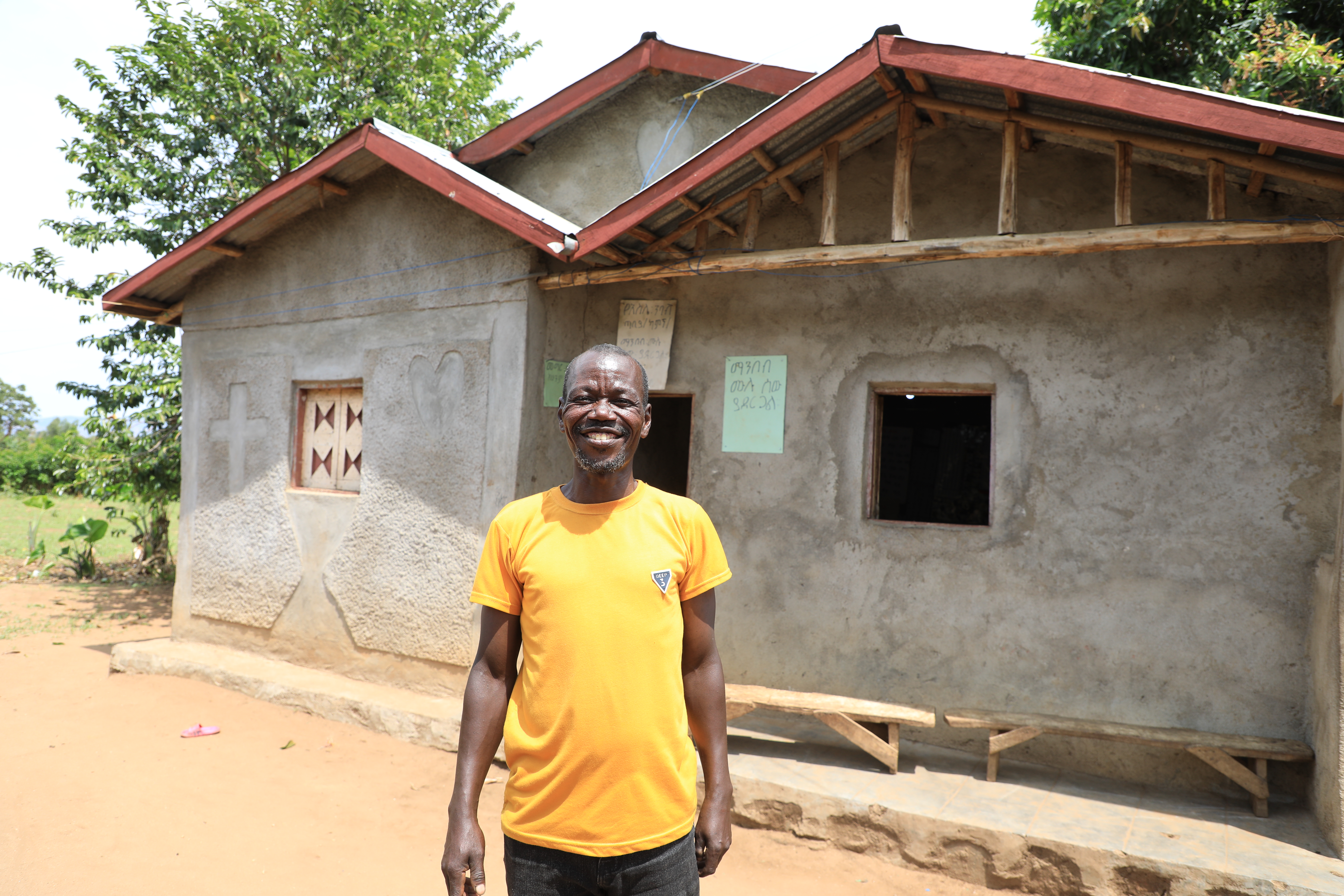 Kifle similing infront of his house