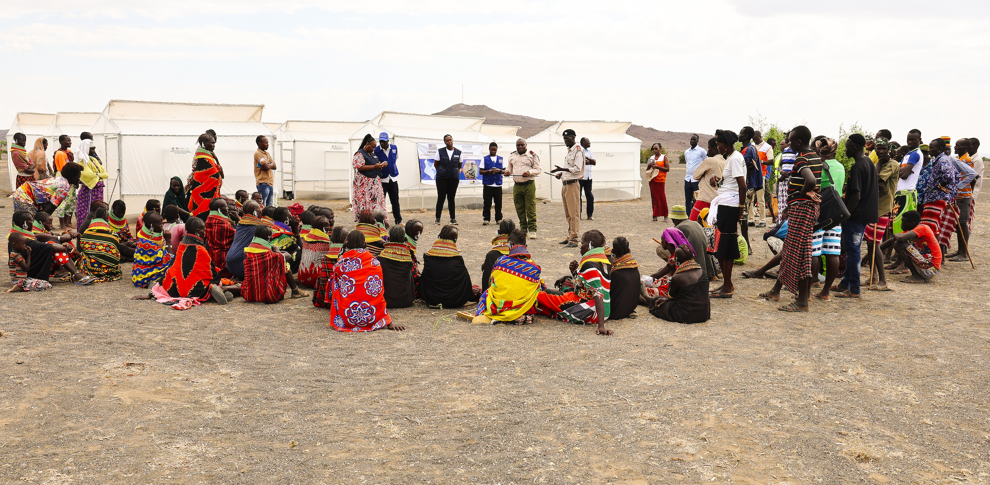 The Assistant County Commissioner and the Moite Village Sub-Chief addressing the beneficiaries of the JTiP Project in Moite Village, Loiyangalani Sub-County, Marsabit County during the official handover of the fish dyers