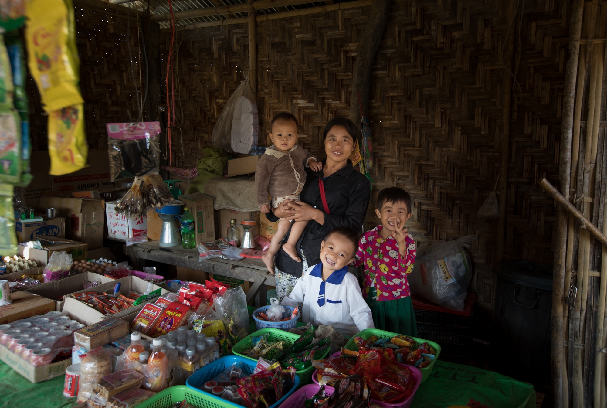 Ngwa, together with her children in front of their grocery shop.