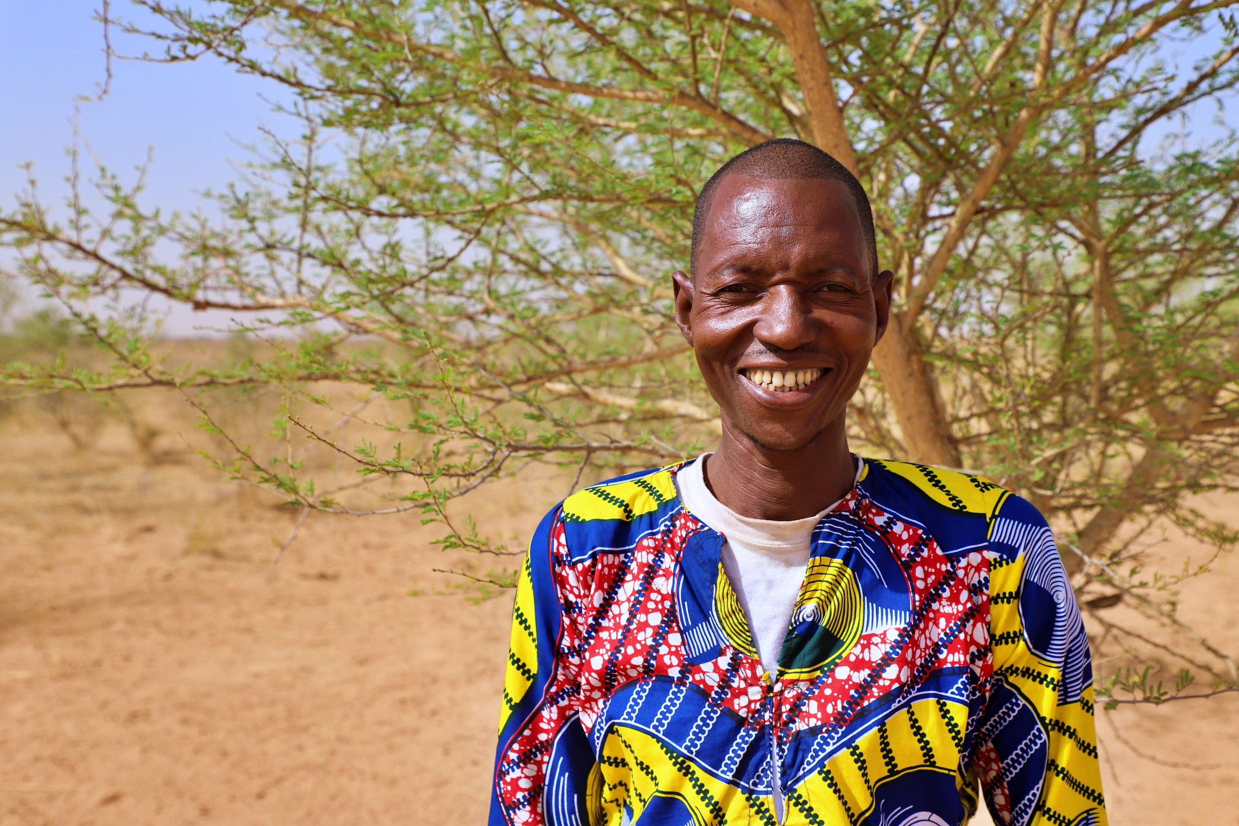 Makan in front on a tree on his farm.