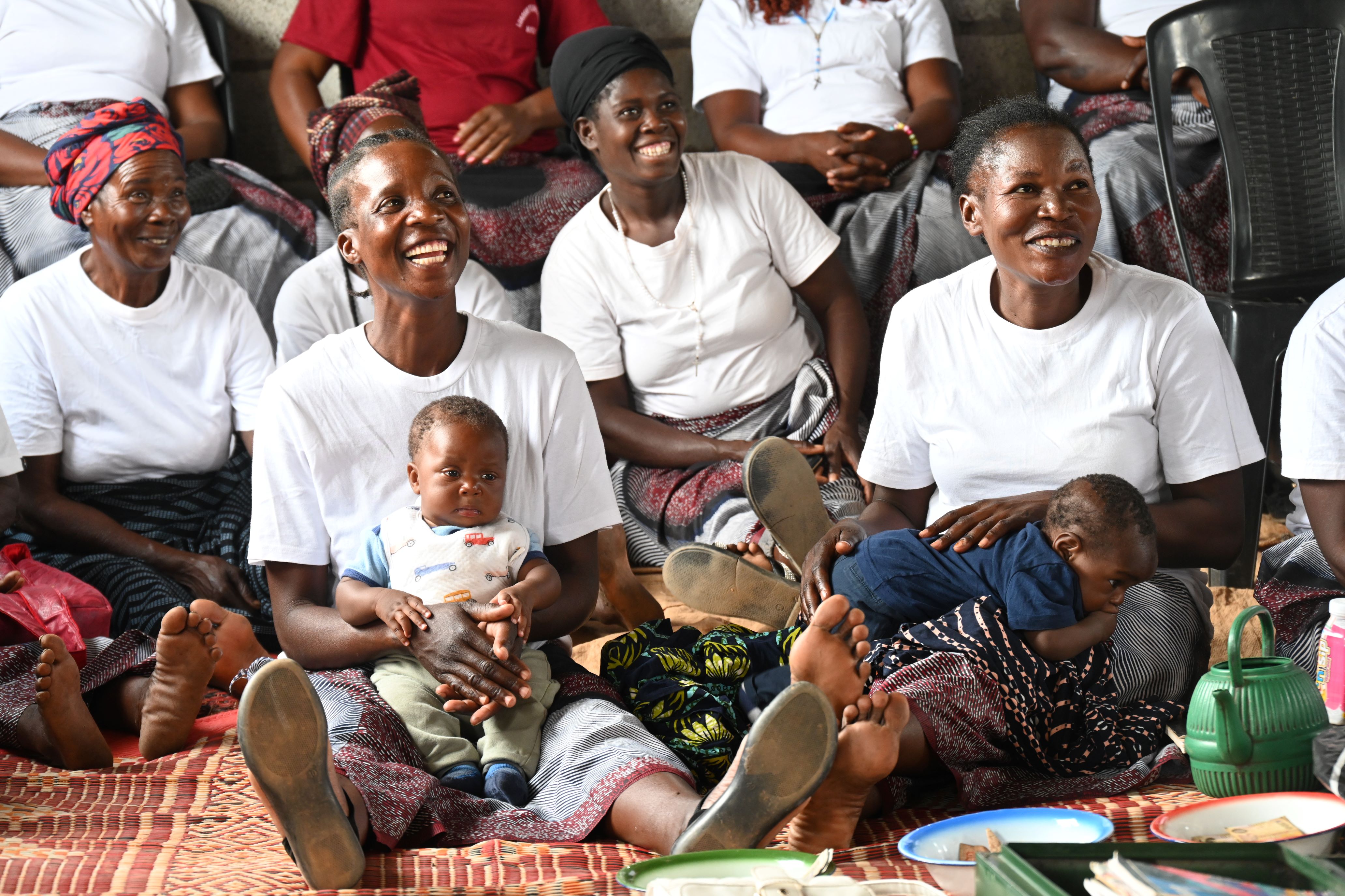 women from the Lukoshi Savings Group in Zambia, along with their children.