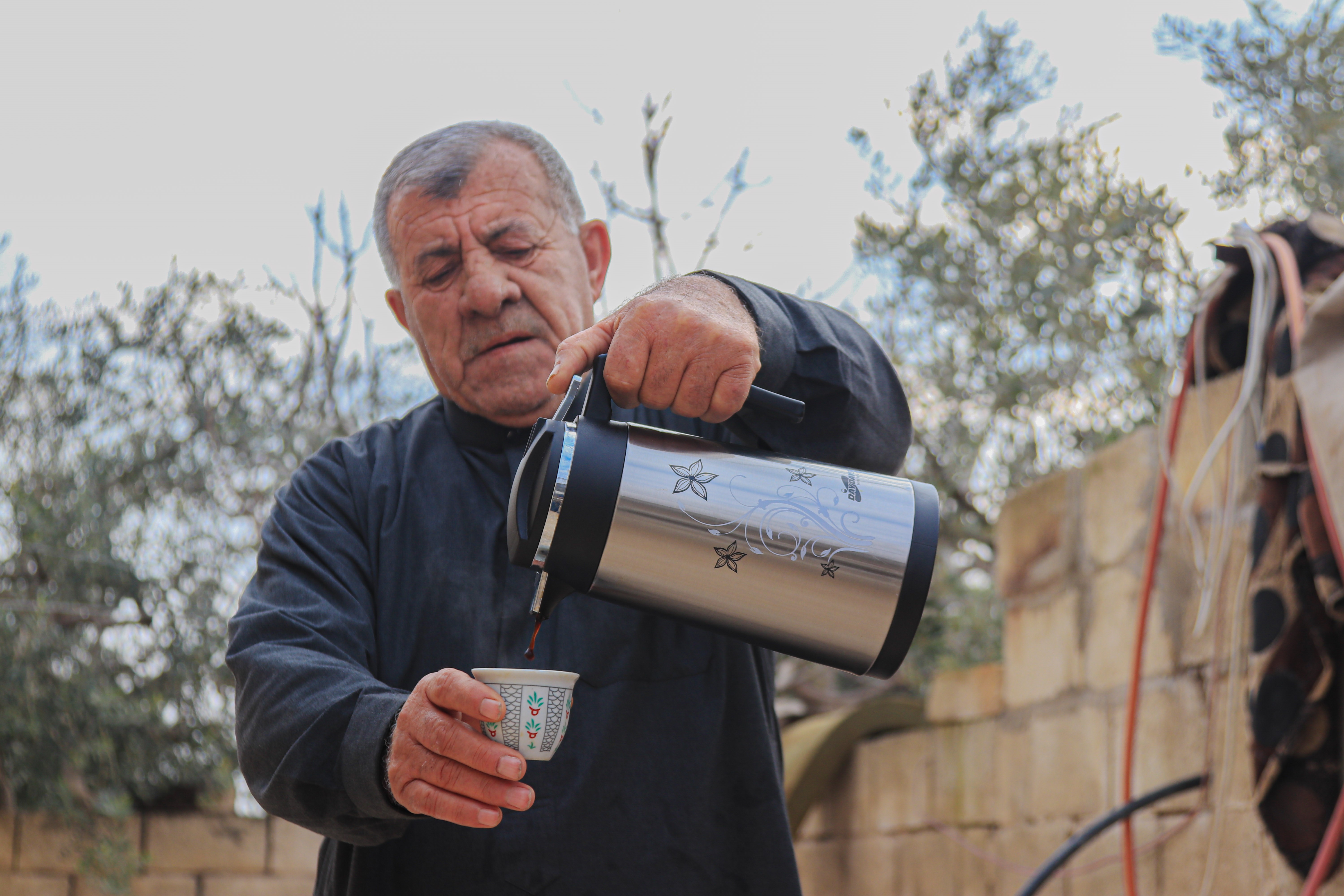 Jassar in pouring coffee to the guests in his home.  ©ULUSLARARASI INSANI YARDIMLAŞMA DERNEĞI, World Vision’s Partner 