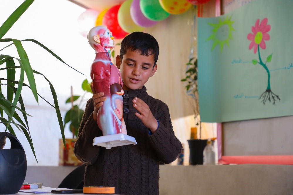 Karam plays the teacher’s role to explain body parts. ⒸWorld Vision Syria Response, Zaher Jaber