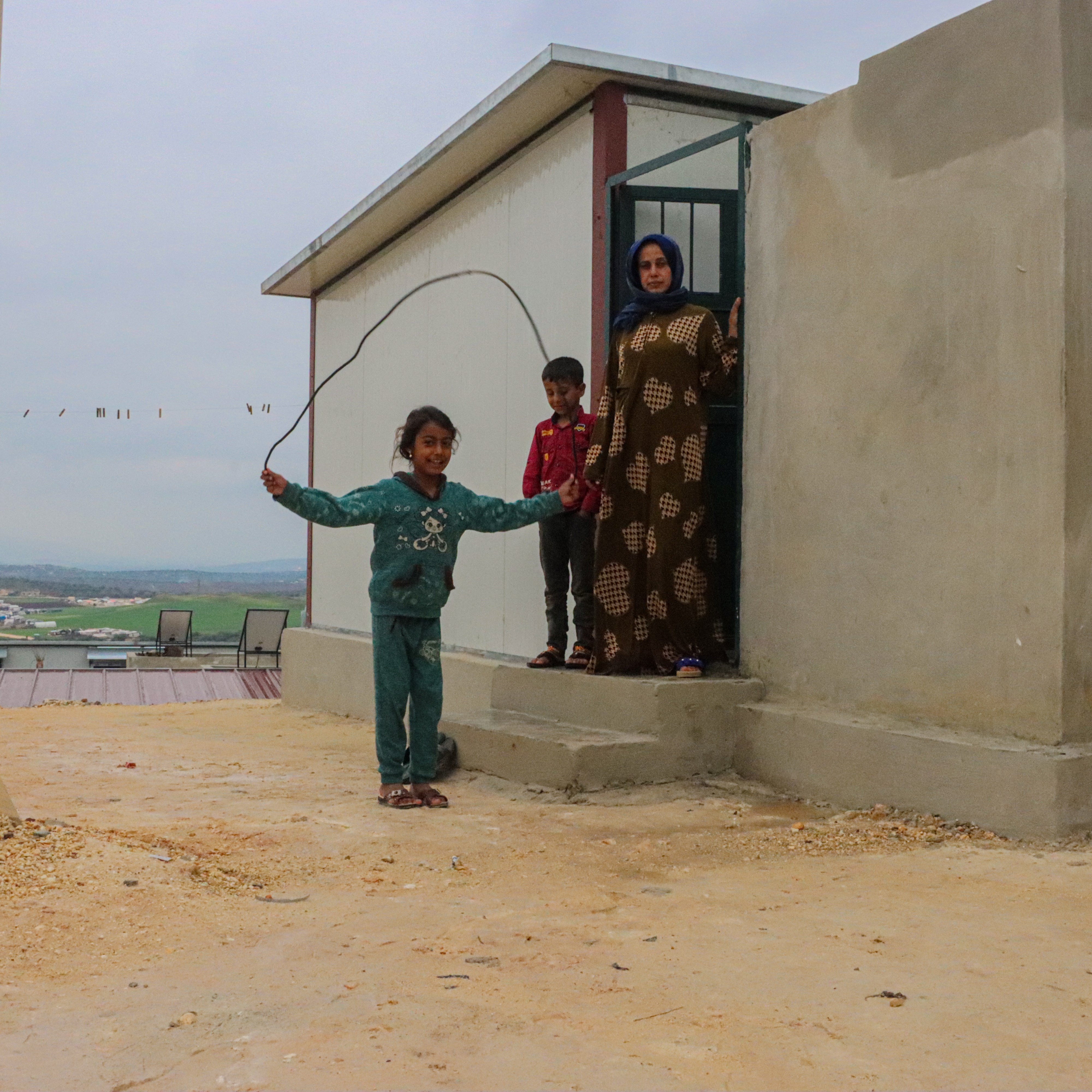 Lana with her children in front of their home World Vision Syria Response Partner, World Vision Syria Response Partner, Takaful Al Sham Organisation Organisation