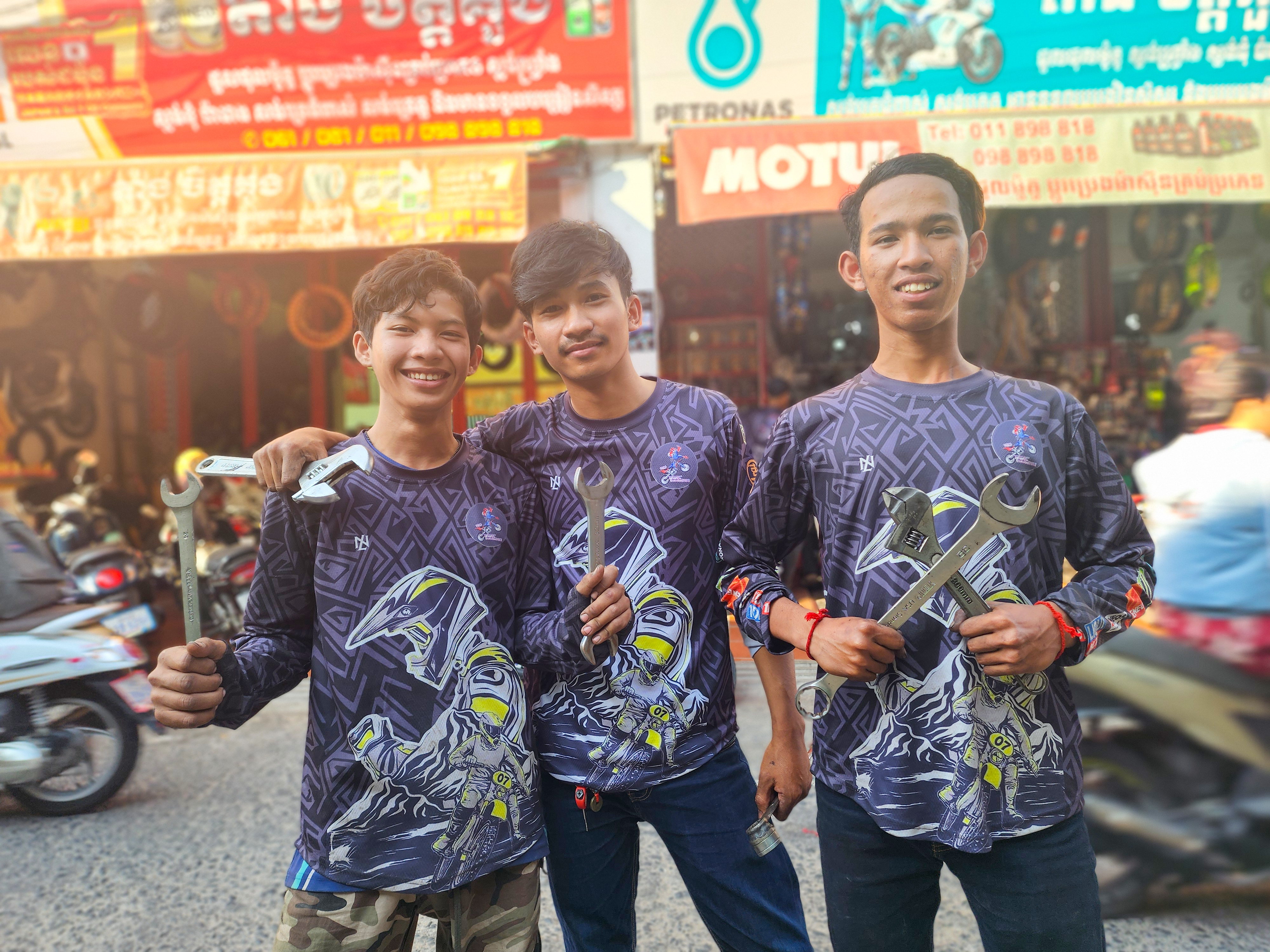 Heng is on the right side of his friends who also received vocational training in motorcycle repair with the support of World Vision.