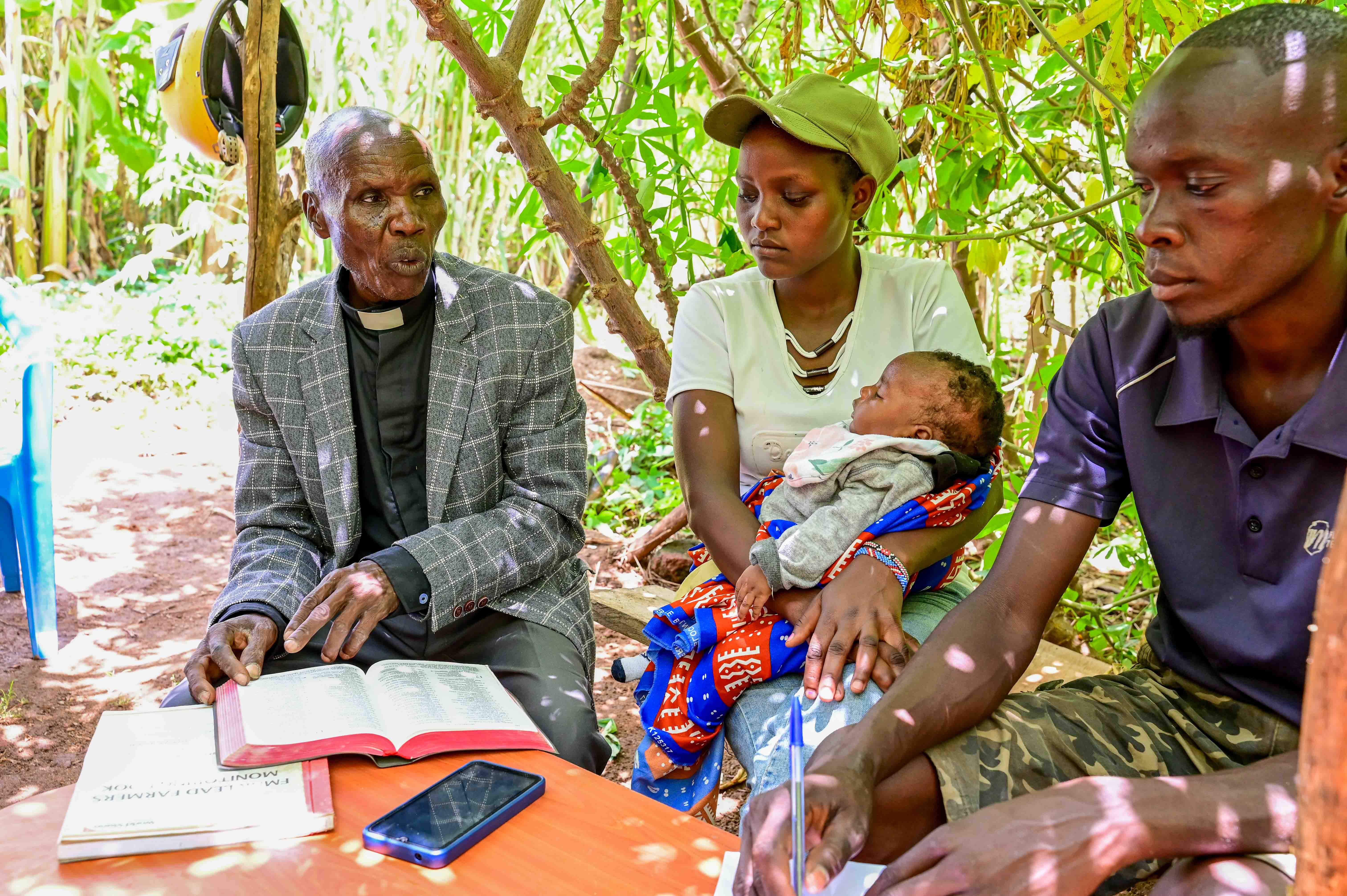 Pastor Wilson (left) leads a Bible study session with Shavine (center) and Evans (right), both replicate farmers, who first learned about FMNR through his teachings at church. ©World Vision Photo/Hellen Owuor