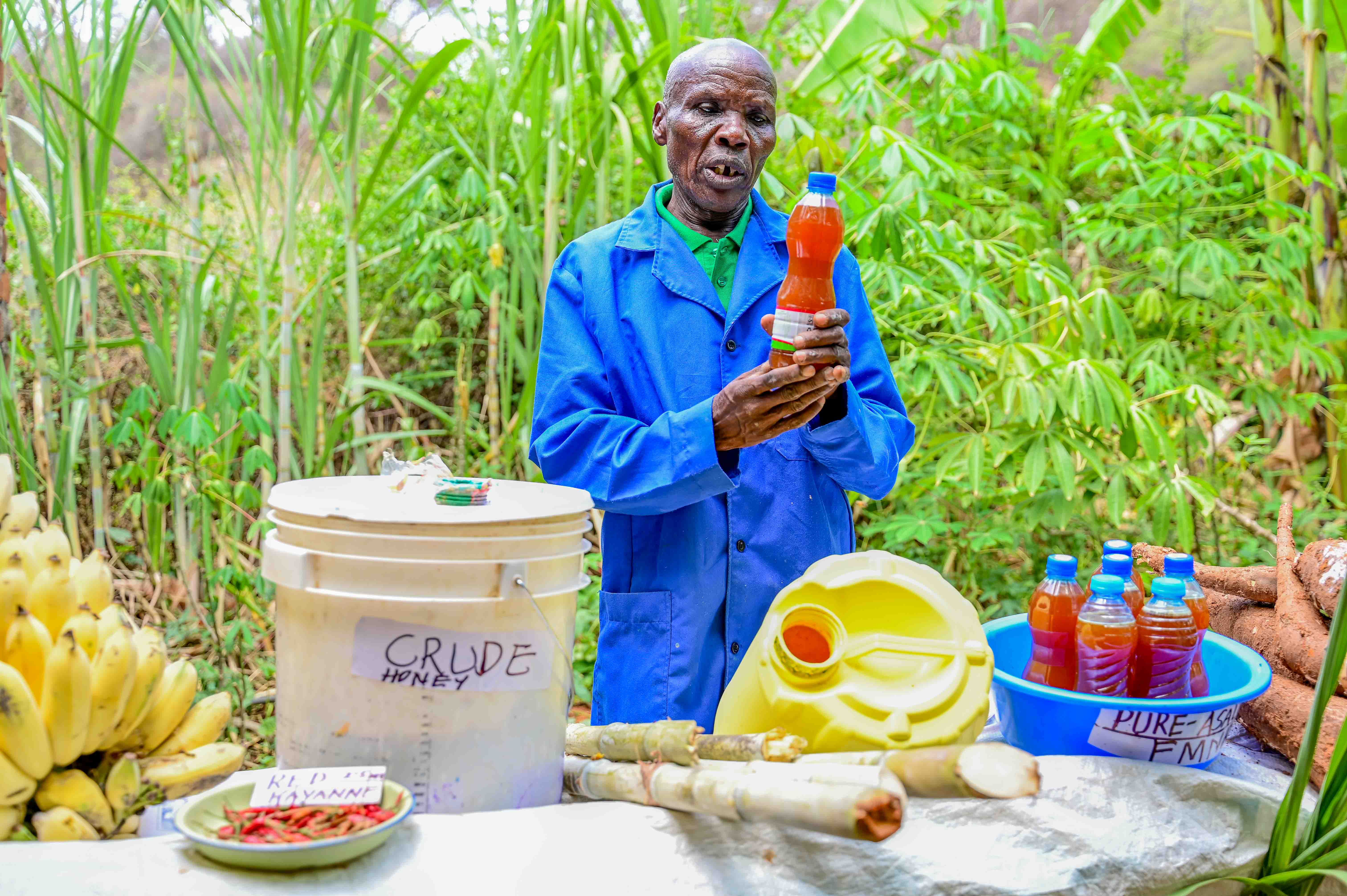 Pastor Wilson showcases a variety of farm produce from his land, including bananas, sugarcane, red cayenne pepper, cassava, and honey, which serve as alternative sources of income. © World Vision Photo / Hellen Owuor