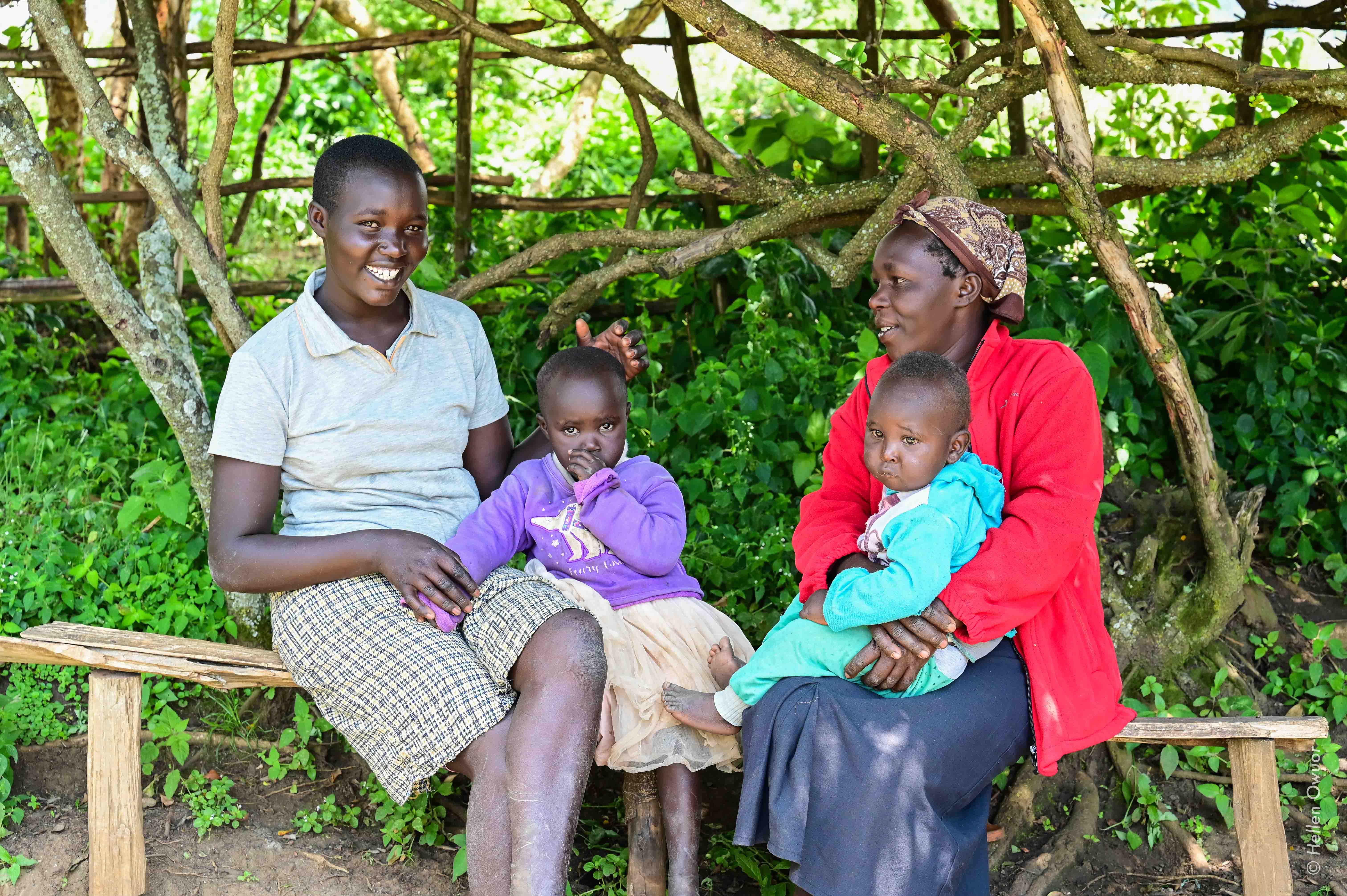 Scholastica sits under a shade with one of her daughters and her grandchildren. She is determined to offer the best future for her family. ©World Vision Photo/ Hellen Owuor