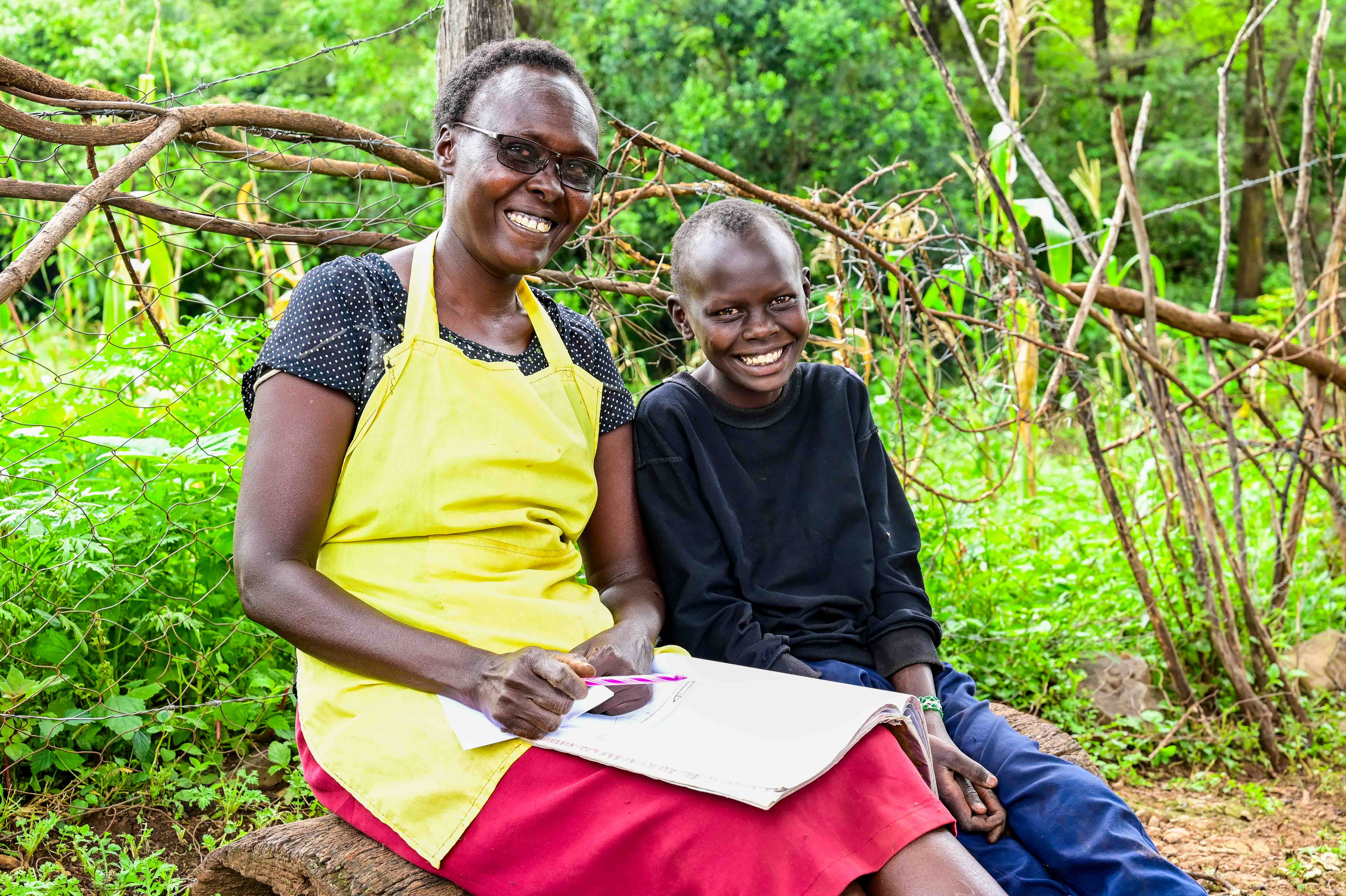 With her farm thriving, Salina can now dedicate more time to her children, sometimes even helping them with schoolwork. ©World Vision Photo/ Hellen Owuor