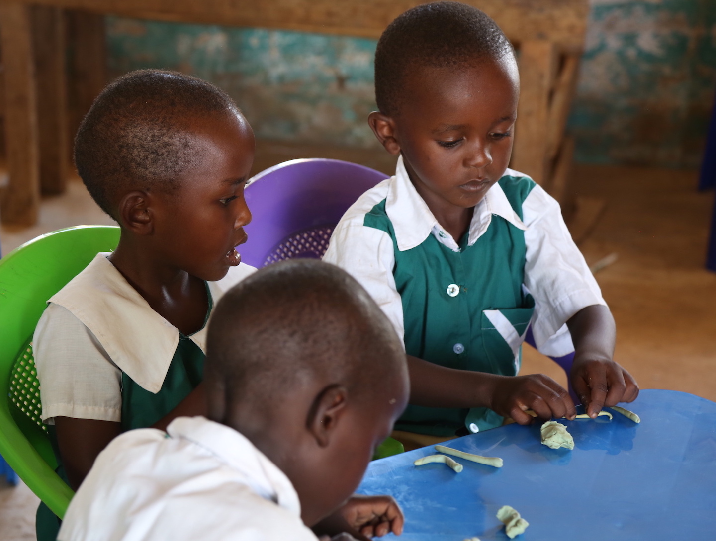 Children enjoy playing with modelling clay that comes with the School-in-a- Box Kit. © World Vision Photo/Sarah Ooko