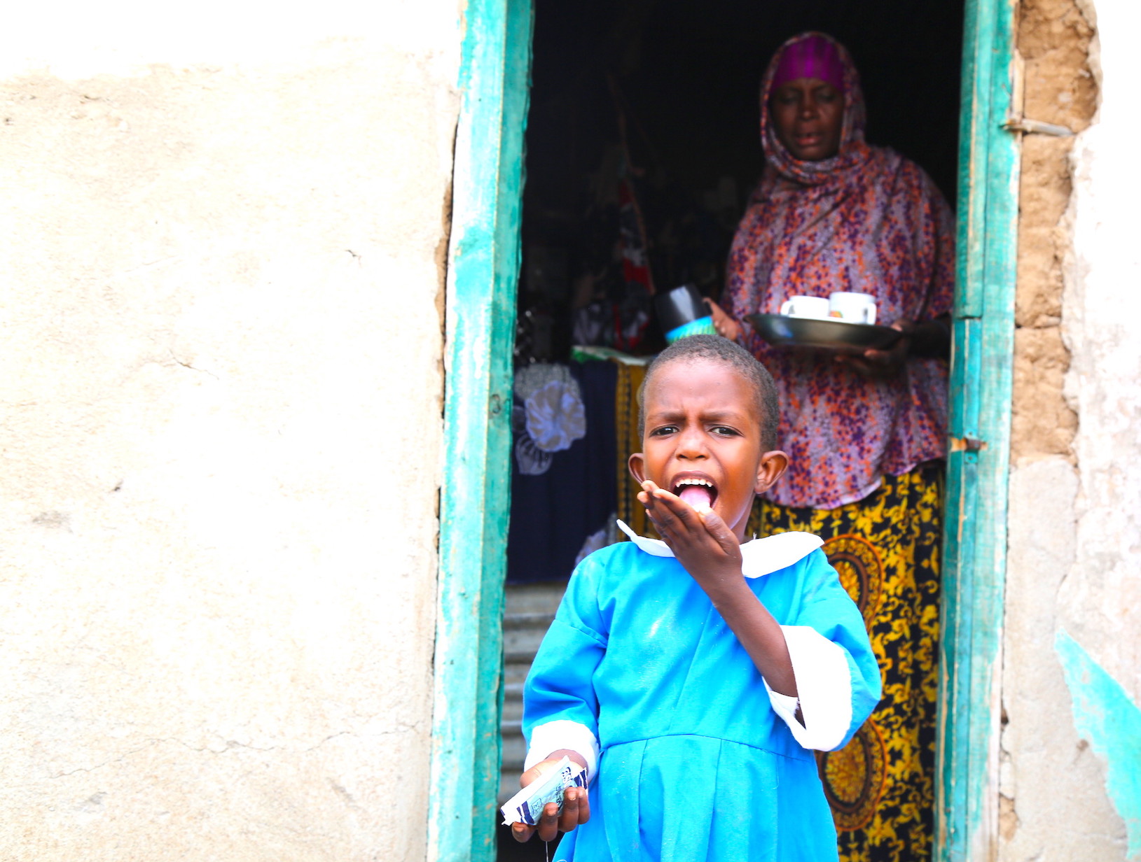 Nawal enjoys a snack at her Mom's shop.